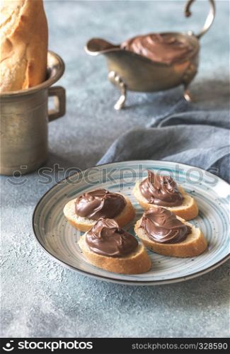 Slices of baguette with chocolate cream on the plate