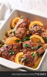 Slices of baked chicken in a creamy sauce with oranges and capers in a baking dish