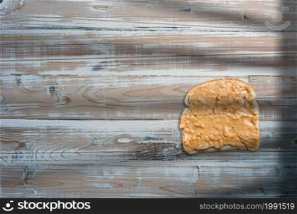 Slices of bread, sandwich with peanut butter on old wooden table.