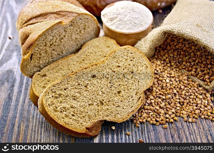 Slices of buckwheat bread, a bag of buckwheat, buckwheat flour in a bowl on a wooden boards background
