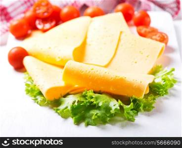 slices of cheese with tomatoes on wooden table