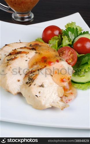 Slices of chicken breast grilled with vegetables and sauce