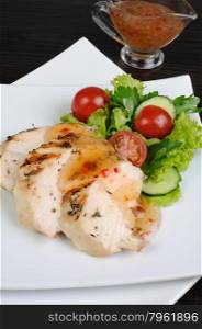 Slices of chicken breast grilled with vegetables and sauce