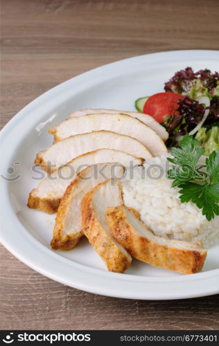 slices of chicken breast with rice and vegetable salad