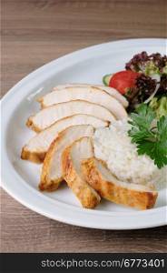 slices of chicken breast with rice and vegetable salad