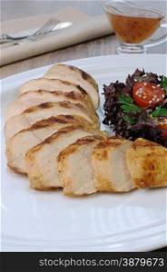slices of chicken grilled with a salad on a plate