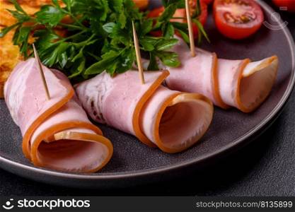 Slices of delicious raw or salted bacon with spices, salt, vegetables and herbs on a wooden cutting board against a dark concrete background. Slices of delicious raw or salted bacon with spices, salt, vegetables and herbs on a wooden cutting board