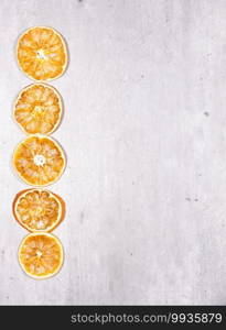 slices of dried oranges on wooden background with space to write a text