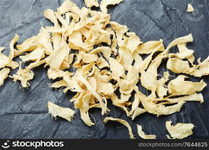 Slices of dry ginger and raw rhizome ginger. Dried ginger root.