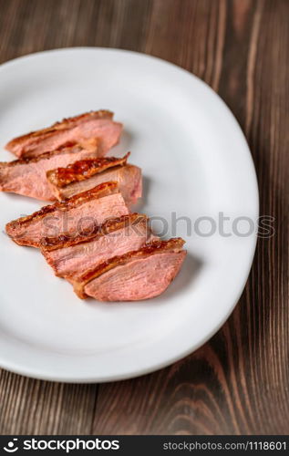 Slices of duck breast on the white plate