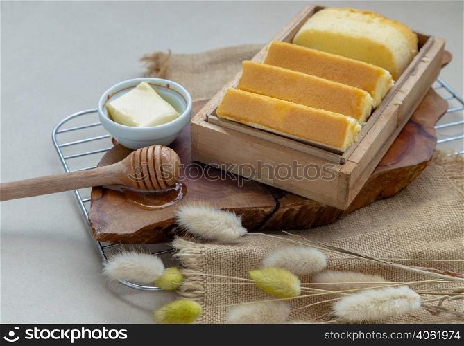 Slices of four butter cakes in wooden box served with butter and honey. Selective focus.