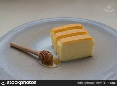 Slices of four butter cakes in wooden box with honey. Selective focus.