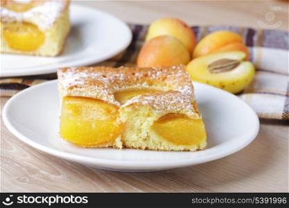 Slices of fresh apricot iced sponge cake with fruits