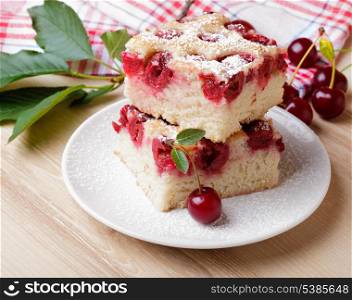Slices of fresh cherry iced sponge cake with berries