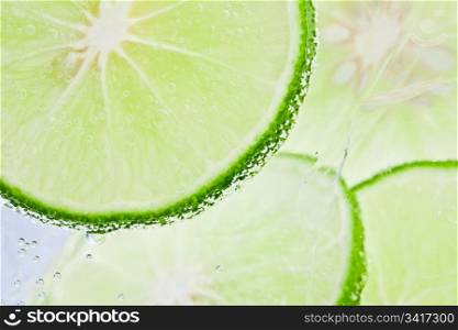 Slices of fresh lime floating in sparkling water