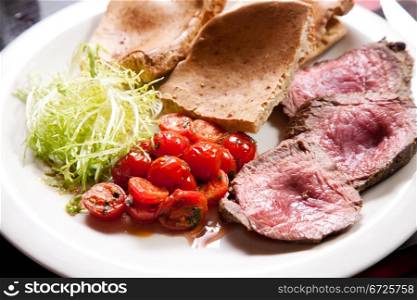 Slices of juicy roast beef with vegetables