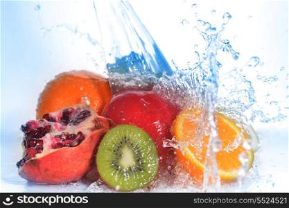 slices of kiwi, orange, pomegranate and lemon in water