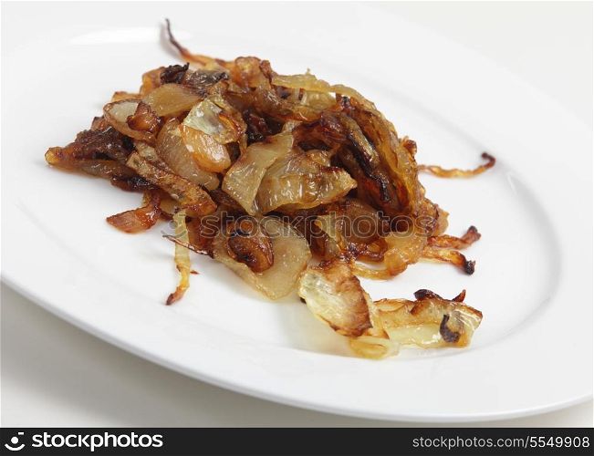 Slices of onion that have been caramelised as part of the process of making biryani