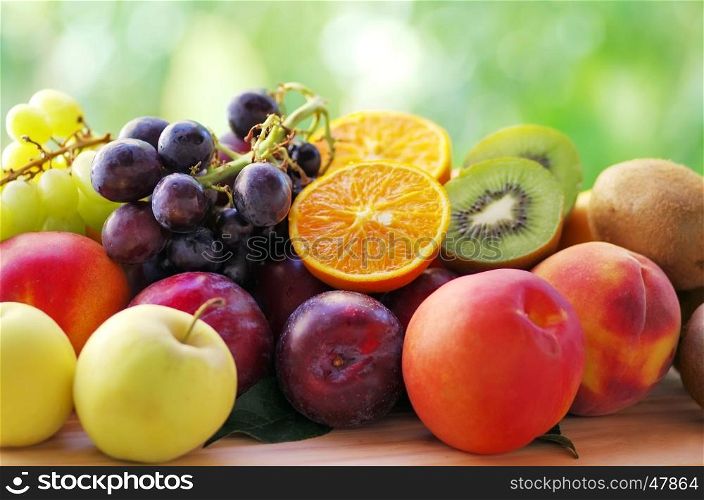 Slices of orange and kiwi fruits, grapes and plums