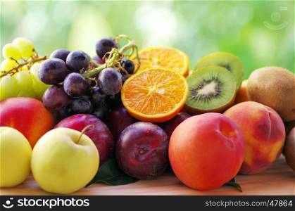 Slices of orange and kiwi fruits, grapes and plums