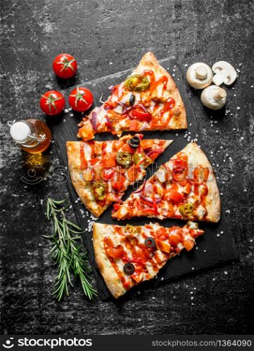 Slices of pizza with tomatoes, jalapeno peppers and sausages. On dark rustic background. Slices of pizza with tomatoes, jalapeno peppers and sausages.