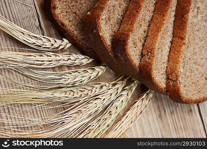 slices of rye bread and ears of corn on the wooden table