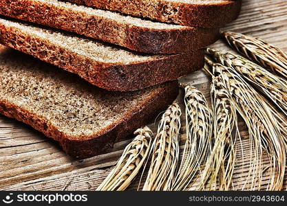 slices of rye bread and ears of corn on the wooden table