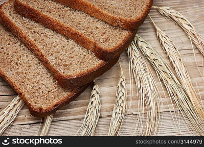 slices of rye bread and ears of corn on the wooden table