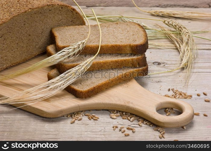 slices of rye bread and ears of corn on the wooden table