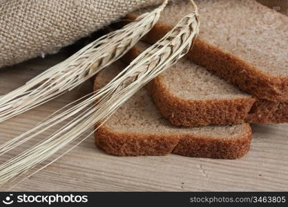 slices of rye bread and ears of corn on the wooden table