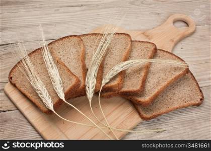 slices of rye bread and ears of corn on the wooden table