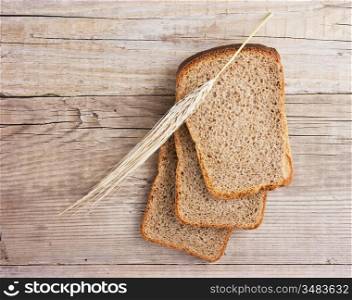 slices of rye bread and ears of corn on the wooden table