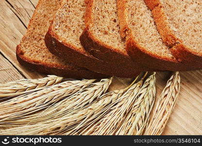 slices of rye bread and ears of corn on the wooden table