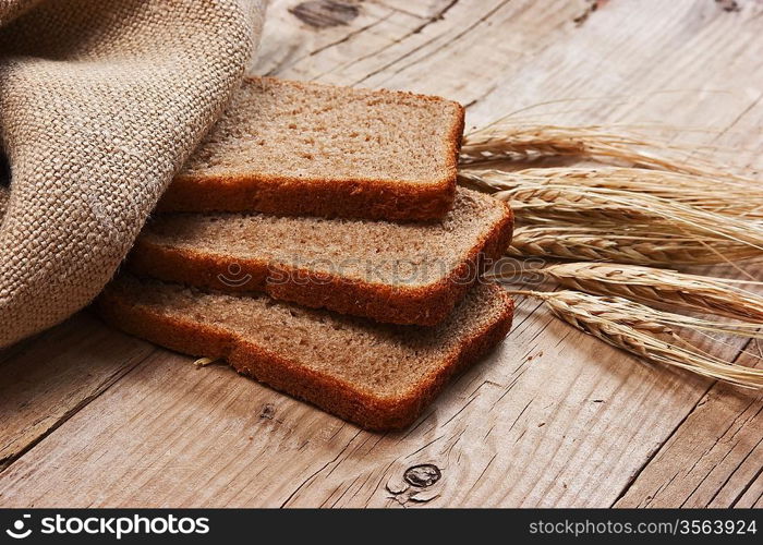 slices of rye bread and ears of corn on the wooden table