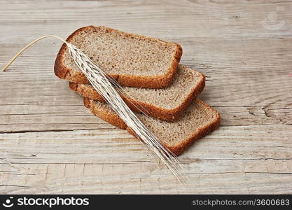 slices of rye bread and ears of corn on the wooden table