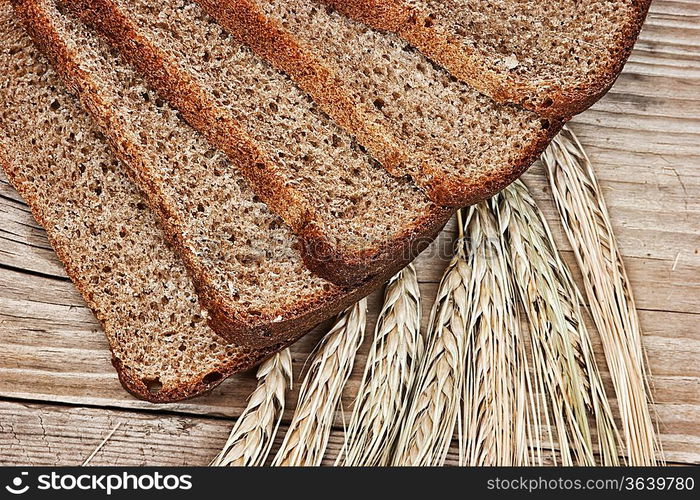 slices of rye bread and ears of corn on the wooden table