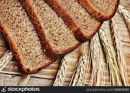 slices of rye bread and ears of corn on the wooden table