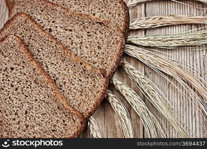 slices of rye bread and ears of corn on the wooden table