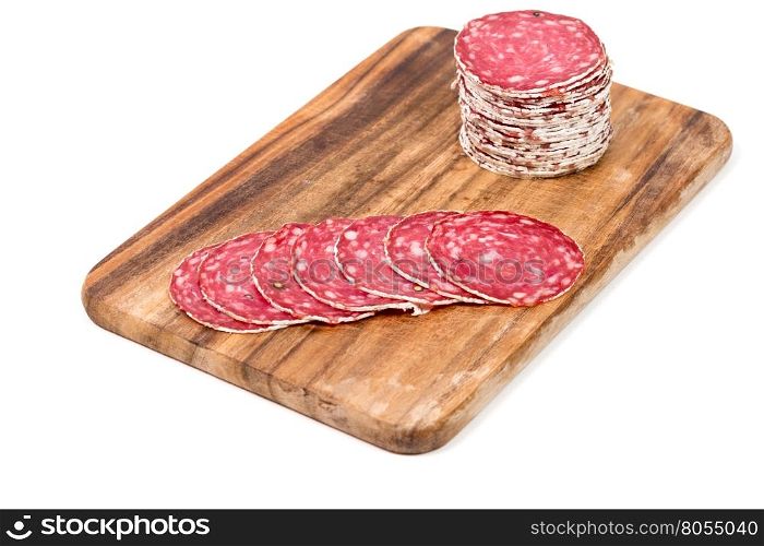 Slices of salami sausages on wooden board isolated