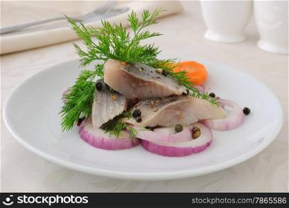 Slices of salted herring fillet with onion and spices