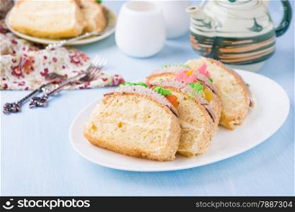 Slices of sponge cake with buttercream on plate served for tea, selective focus