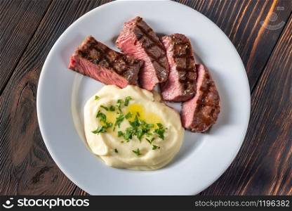 Slices of strip steak with celery puree