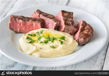 Slices of strip steak with celery puree