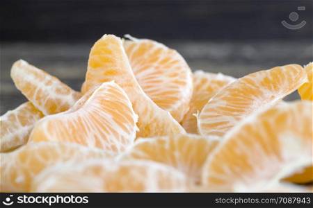 slices of tangerine without peel lying on the table during dessert, close-up of orange citrus, sweet tangerines and not sour. slices of tangerine without peel