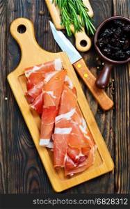 Slices of tasty spanish ham on board