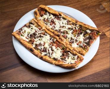 slices of traditional Turkish beef Pide on white plate