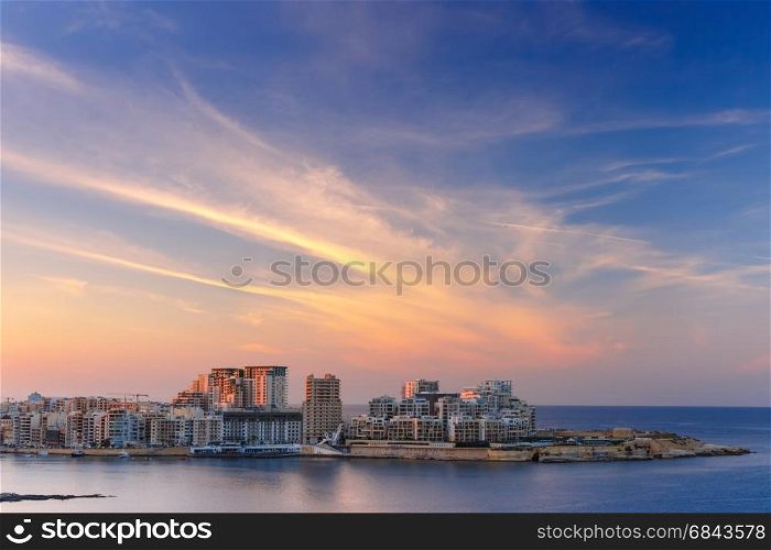 Sliema Skyline at sunset view from Valletta, Malta. Sliema, major residential and commercial area and a centre for shopping, dining, and cafe life in Malta. Skyline in the Strand and Tigne Point at sunset as seen from Valletta