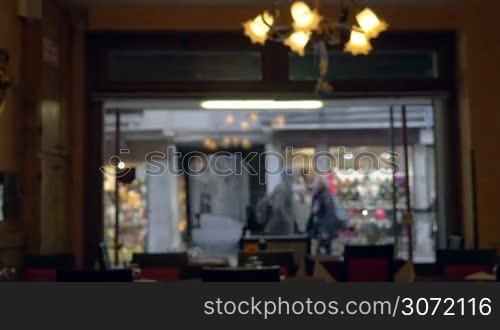 Slight defocus of city street with walking people. View through the cafe or restaurant window