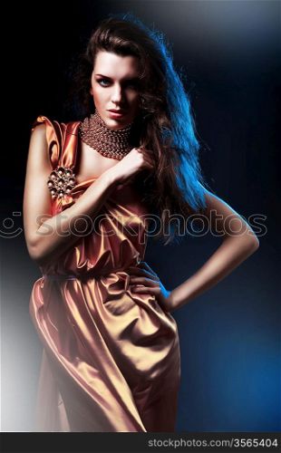 slim attractive woman in pink dress on blue light