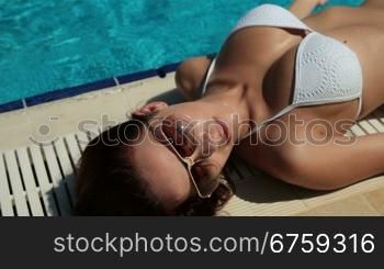 Slim Bikini Female Lying by Swimming Pool at Summer Resort